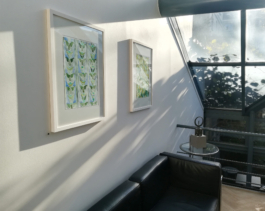 Two watercolor painting in green and blue on a wall, light shinning trough a window. Anna Slobodnik, 2018. 