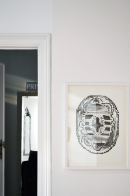 A framed lithograph of a oval carpet on the right, on the left: an open door. Anna Slobodnik, 2018. 