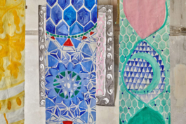 Three hanging canvases infront of a painting on paper. 