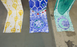 Three hanging paintings on the floor. 