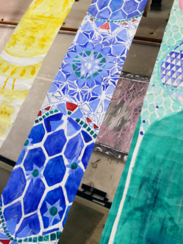 Detail view of three long canvases in yellow, blue and green. 