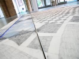 Close up of a drawing which simulates a carpet and lays on the floor. 