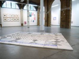Exhibition view of the exhibition Inbetween. An assembled, drawing is lying on the floor. 