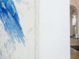 Detail of a big white picture with blue colored drippings on it. 