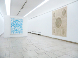 Exhibition view. To the left: a framed painting with blue floral patterns. To the right one big assembled drawing on beige ground. Anna Slobodnik, 2017. 