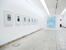 Exhibition view of seven framed black lithographs of carpets and one big painting with blue floral pattern. Anna Slobodnik, 2017. 