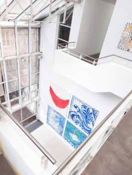 View down on the sun room from the second floor on four high scale canvas paintings. 