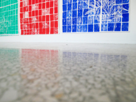 View from the floor of three big paper works, showing tiles in red, green and blue. 