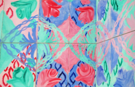 Close up of a painted frieze with flowers in blue, green and red. 