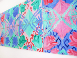 Close up of a painted frieze with flowers in blue, green and red. 