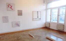 Exhibition view of a room with 5 paintings and small sculptural works on the floor. 