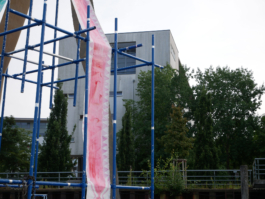 A red ornamented painting before a house. 