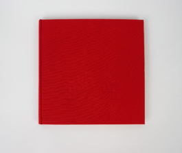 A red book lying on a white background.