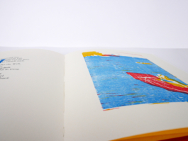 An open book with a woodprint of a lake on the right side.