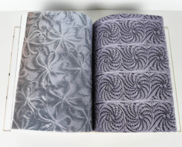 An open book with plants on the left and ornaments on the right side.