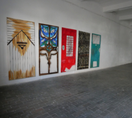 View of five paintings of doors in different colors in oil on canvas. You see them from the left. 