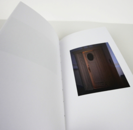 An open book with a photograph of a door to the right.