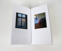 An open book with a photograph of a window to the left and a room to the right.