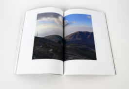 An open book with a photograph of mountains. 