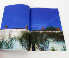 An open book with a photograph of the sky all over it. 