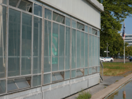 Sideview of a building with a road in the background. 