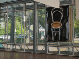 Painting of a chair infront of a window. Outside of the window trees and cars. 