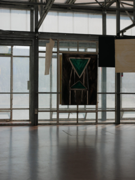 Painting of a green chair and drawings on paper hanging from the ceiling in front of it. 