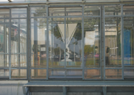 A painting of a triangular glass behind a glass window. 
