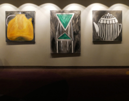 Three paintings of two teapots, yellow and striped in black and white and a futuristic chair in the middle of them. 