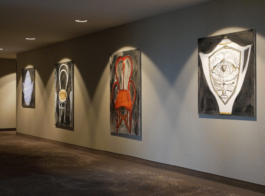 A wall with four paintings: two chairs and two teapots. 