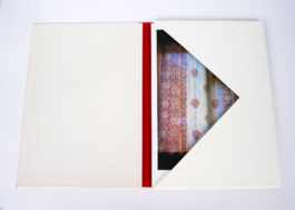 An open book a photograph of a window in it. 