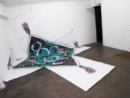 A big room with a painting on paper. The painting shows a scarf with flowers and ribbons. 