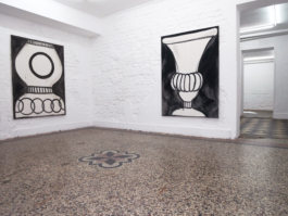 To the left there are two paintings of vases in black and white, to the right we see a passageway to the other exhibition rooms. 