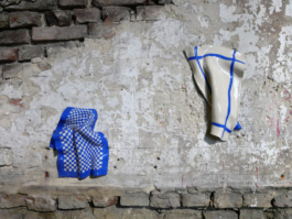 Two ceramic works of kitchen towels, the left one is checkered, the other one has stripes around its sites. 