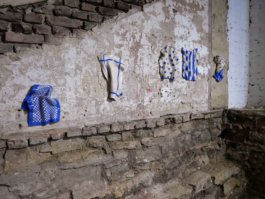 Exhibition view of five ceramic works depicting kitchen towels with different patterns on them. 